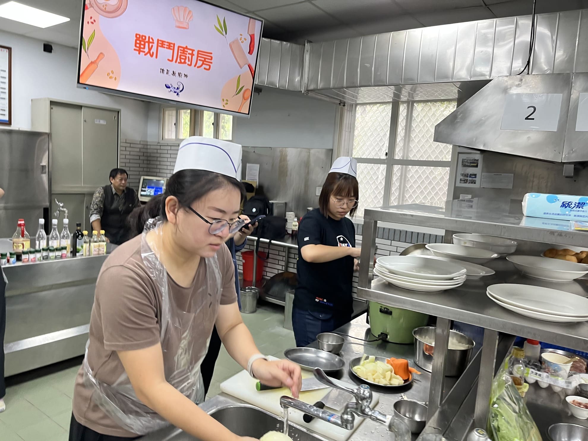 團隊夥伴在廚房中負責洗菜預備的協作過程